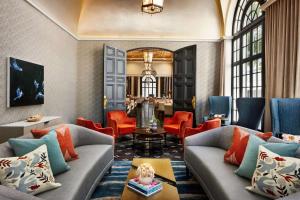 a living room with couches and red chairs at The Terrace Hotel Lakeland, Tapestry Collection by Hilton in Lakeland