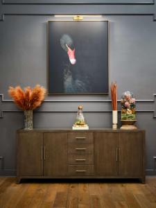 a living room with a television and a dresser at The Terrace Hotel Lakeland, Tapestry Collection by Hilton in Lakeland