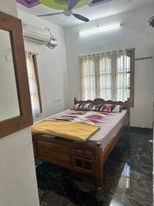 een slaapkamer met een bed in een kamer met een plafond bij YUGA GUEST HOUSE in Kuttālam
