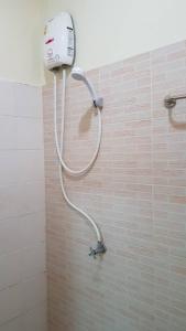 - Baño con ducha y pared de azulejos en T-Bird Grand Hotel Trang ทีเบิร์ดแกรนด์, en Trang