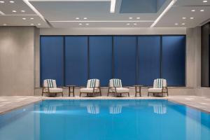 a hotel room with a swimming pool and chairs at Canopy By Hilton Toronto Yorkville in Toronto