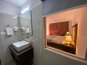 ein Badezimmer mit Waschbecken und Spiegel und einem Bett in der Unterkunft Lha-Zes in Leh
