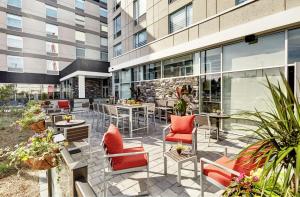 a patio with chairs and tables and a building at Hilton Garden Inn Toronto/Brampton West, Ontario, Canada in Brampton
