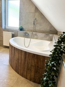 a bathroom with a bath tub with a shower at Wellness Chata Panorama in Dolní Podluží