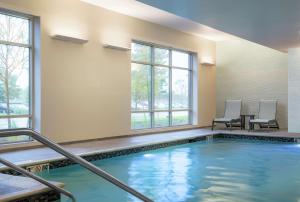 una piscina con 2 sillas y una mesa en Homewood Suites by Hilton Needham Boston, en Needham