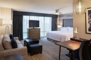 Homewood Suites by Hilton Needham Boston في نيدهام: غرفة فندق بسرير وتلفزيون