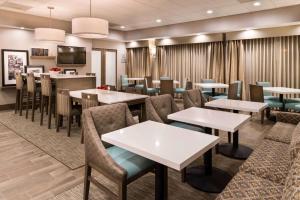 奧克斯納德的住宿－海峽群島港漢普頓酒店，一间带桌椅的餐厅和一间酒吧