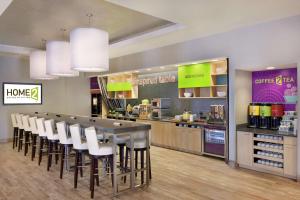 a restaurant with a long table and white chairs at Home2 Suites by Hilton Austin North/Near the Domain, TX in Austin