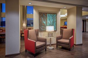 a lobby with two chairs and a table and a painting at Hampton Inn & Suites Hood River in Hood River
