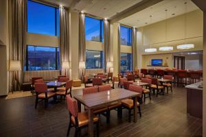a restaurant with tables and chairs and large windows at Hampton Inn & Suites Hood River in Hood River