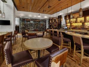 um restaurante com mesas e cadeiras e um bar em Hilton Harrisburg near Hershey Park em Harrisburg