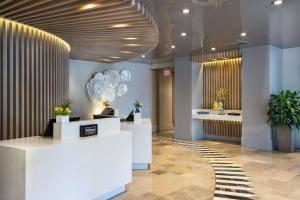 a lobby of a store with white counters and plants at Hilton Bentley Miami South Beach in Miami Beach