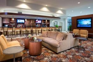 um átrio de hotel com um bar com um sofá e mesas em DoubleTree by Hilton Lafayette em Lafayette