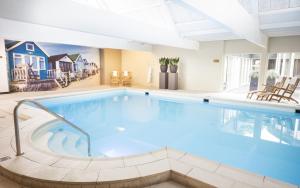 een groot zwembad in een grote kamer met bij Hotel De Bilderberg in Oosterbeek