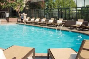 een groot zwembad met ligstoelen en tafels in een hotel bij DoubleTree by Hilton Lafayette in Lafayette