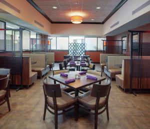 una sala da pranzo con tavoli, sedie e cabine di DoubleTree Suites by Hilton Bentonville a Bentonville