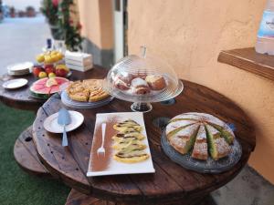a wooden table with pastries and desserts on it at Hera Tropea Rooms in Tropea