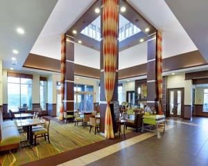 a lobby of a hotel with tables and chairs at Hilton Garden Inn Springfield, MO in Springfield