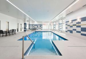a pool in a building with blue and white tiles at Hampton Inn & Suites By Hilton Quebec City /Saint-Romuald in Lévis