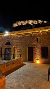 um grande edifício de pedra à noite com uma luz em Fairouz Konak Otel em Mardin