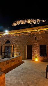 Fairouz Konak Otel في ماردين: مبنى حجري كبير في الليل مع ضوء