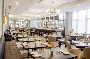 un ristorante con tavoli e sedie e un bar di DoubleTree by Hilton Charlottesville a Charlottesville