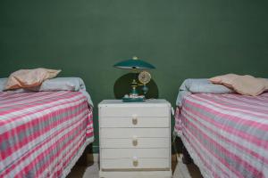 ein Schlafzimmer mit 2 Betten und einem Nachttisch mit einer Lampe in der Unterkunft CASA LA QUEBRADA in Cordoba