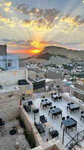 馬爾丁的住宿－Fairouz Konak Otel，屋顶上一组桌子,享有日落美景