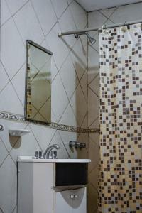ein Badezimmer mit Waschbecken und Dusche mit Spiegel in der Unterkunft CASA LA QUEBRADA in Cordoba