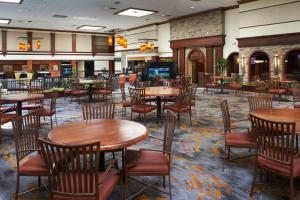a restaurant with tables and chairs in a room at DoubleTree by Hilton Dearborn in Dearborn