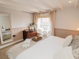 a bedroom with a large white bed and a large window at Goosedale Cottage in Scarborough