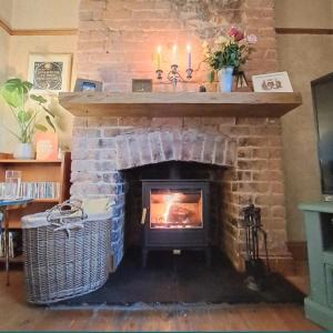 a brick fireplace with a fire in it at Room in a Cosy Cottage close to Cardiff City Centre 