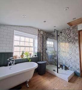 a large bathroom with a tub and a shower at Room in a Cosy Cottage close to Cardiff City Centre 