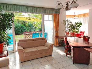 ein Wohnzimmer mit einem Sofa und einem Tisch mit einem Sonnenschirm in der Unterkunft Dali Apartment Szentendre in Szentendre