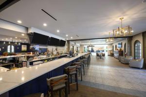 a restaurant with a bar with stools at Estancia del Norte San Antonio, A Tapestry Hotel by Hilton in San Antonio