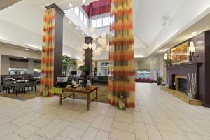 eine Lobby eines Hotels mit einem Kamin und Tischen in der Unterkunft Hilton Garden Inn Lawton-Fort Sill in Lawton
