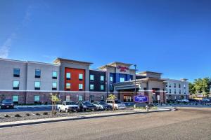 a street with cars parked in front of a building at Hampton Inn Fresno Airport in Fresno