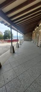 une rangée de bancs assis sous un bâtiment dans l'établissement Albergue Villa de Salvatierra, à Salvatierra de Tormes