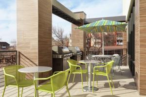 a patio with tables and chairs and an outdoor grill at Home2 Suites by Hilton Salt Lake City-East in Salt Lake City