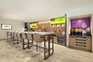 a kitchen with a bar with chairs in a store at Home2 Suites by Hilton Salt Lake City-East in Salt Lake City