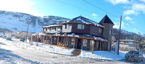 una casa está cubierta de nieve en una calle en Aparts Complejo Ricanor en El Chaltén