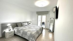biała sypialnia z łóżkiem i oknem w obiekcie Apartamento con vistas a mar y canal. Empuriabrava w mieście Empuriabrava