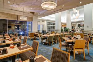 a restaurant with wooden tables and chairs at Hilton Garden Inn Toronto/Mississauga in Mississauga