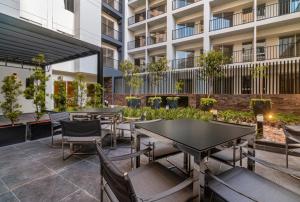 an outdoor patio with tables and chairs and a building at Departamento de Estreno en Barranco in Lima