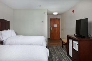 a hotel room with two beds and a flat screen tv at Hampton Inn Helena in Helena