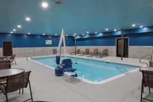 a large pool with chairs and a table and a table and chairs at Hampton Inn Hutchinson in Hutchinson