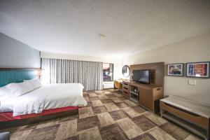 a hotel room with a bed and a flat screen tv at Hampton Inn Hutchinson in Hutchinson