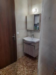 a small bathroom with a sink and a shower at Pezoulia Cottages in Samothráki