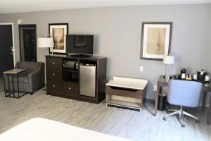 a living room with a tv and a desk with a computer at Hampton Inn Indianapolis NW/Zionsville in Whitestown