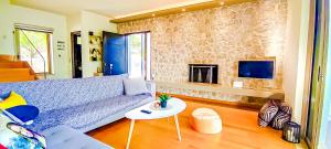 a living room with a blue couch and a fireplace at Avatonblue Villa Nafplio in Vivari